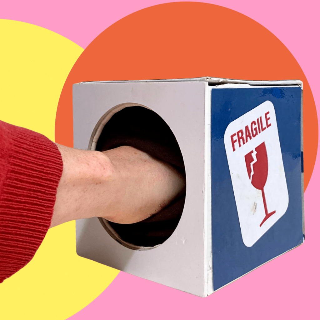 boîte dans laquelle quelqu'un glisse la main pour sentir la texture d'un verre imprimé