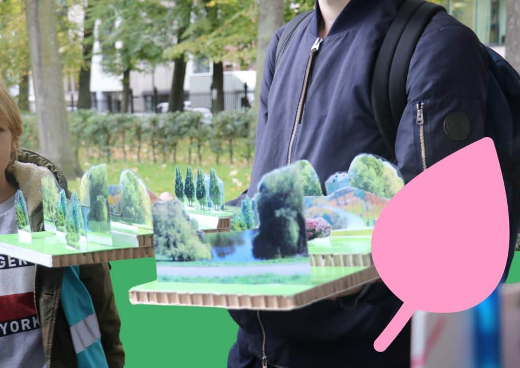 Twee leerlingen doe een oefening in een groene ruimte met een maquette.