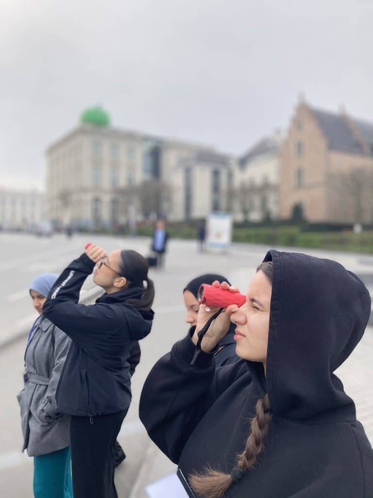 Des élèves observent à la longue vue la façade de la pharmacie Delacre