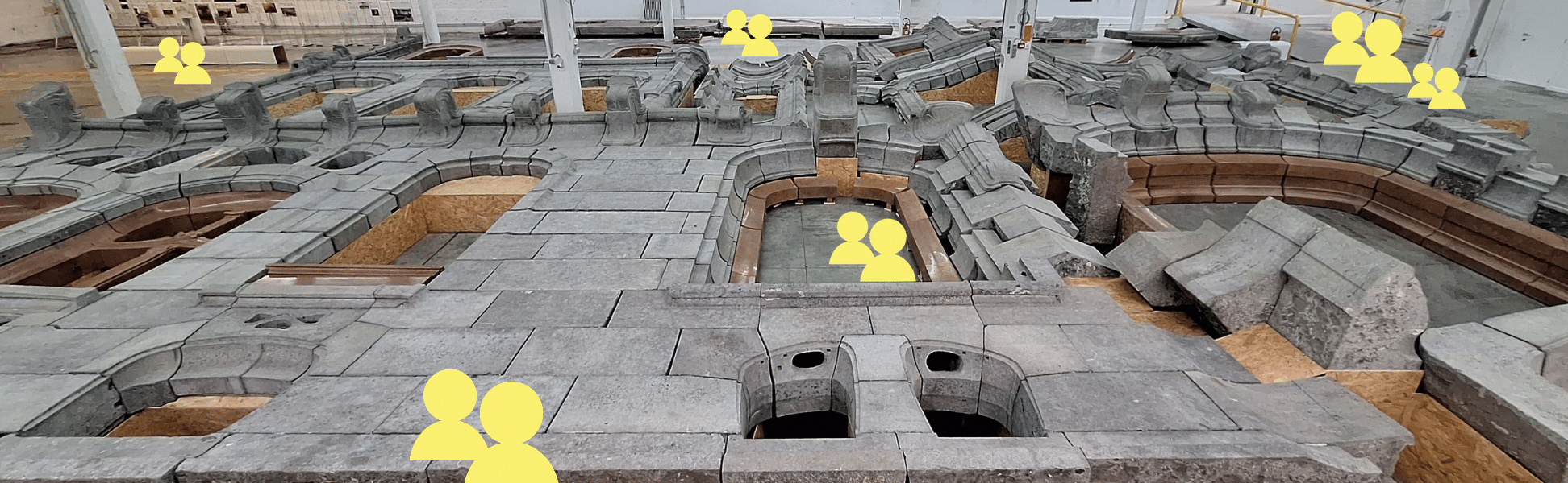 Une photographie des pierres de la façades Aubecq avec des petits pictogrammes personnages jaunes mis en scène entre les pierres